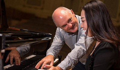 Simon Rowe with student at a grand piano