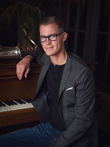 Greg Johnson portrait sitting at the piano
